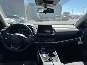 Interior image of a Nissan Rogue showing the steering wheel and infotainment system